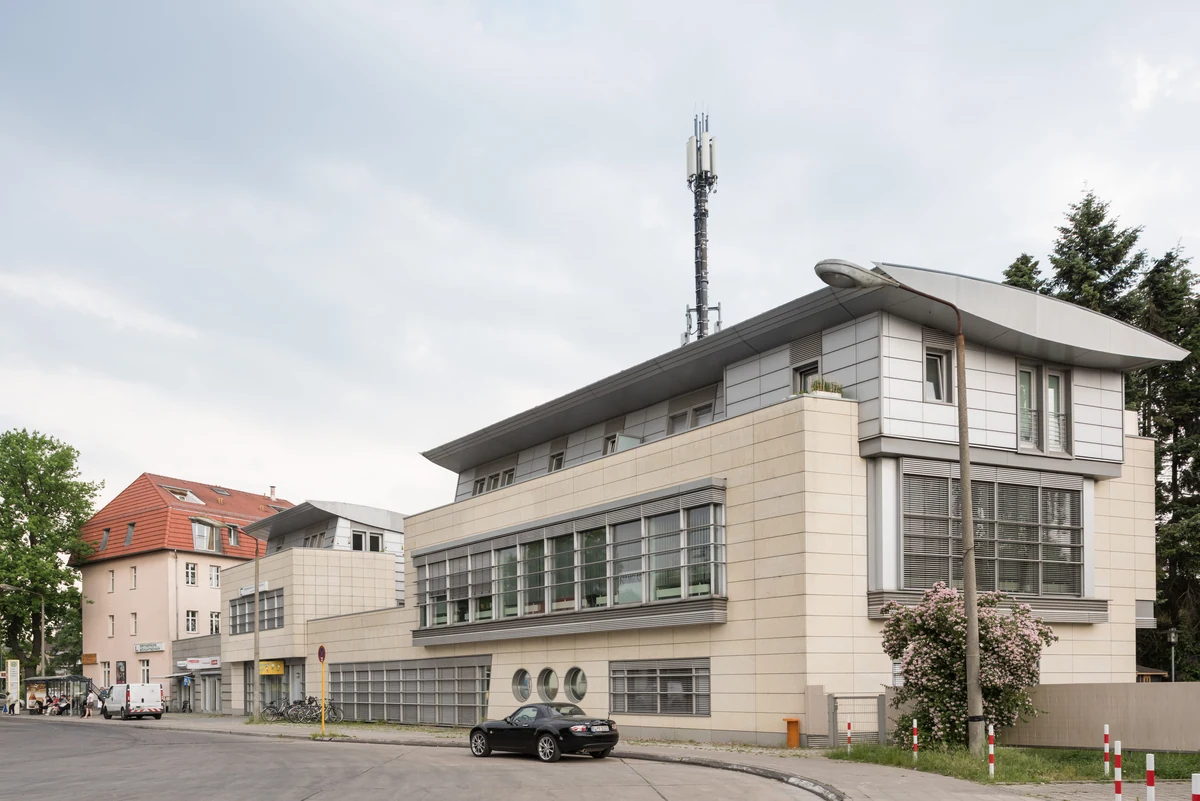 Wohn- und Geschäftshaus mit heller Fassade an einer Straße in Berlin-Kaulsdorf