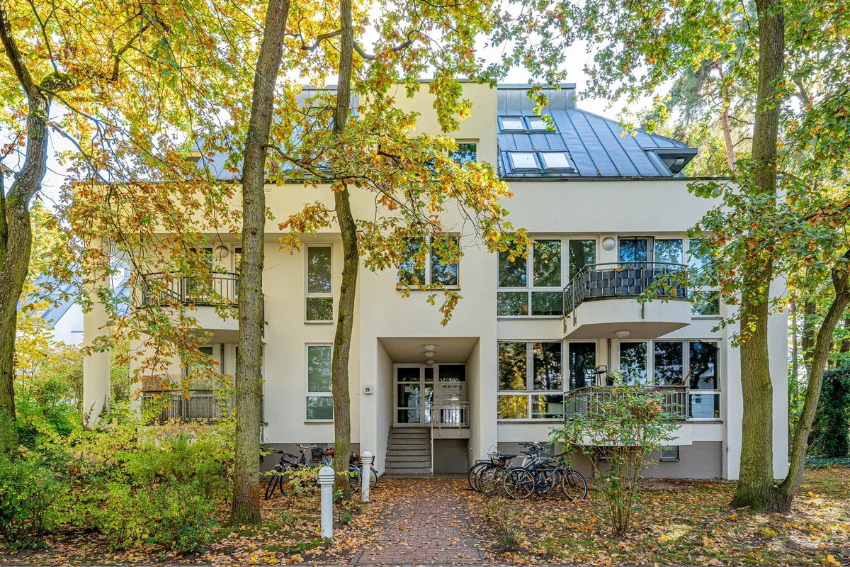 Wohngebäude in Potsdam-Babelsberg mit Balkonen hinter herbstlichen Bäumen
